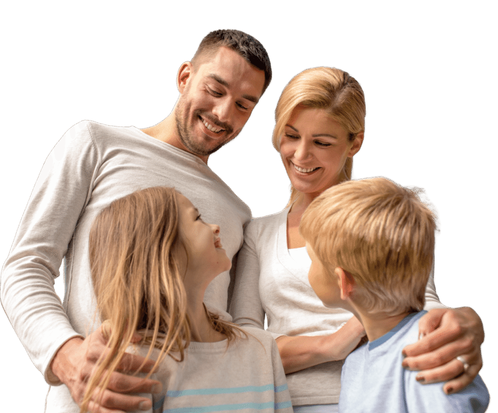 A happy family of four: parents embracing a young boy and girl.